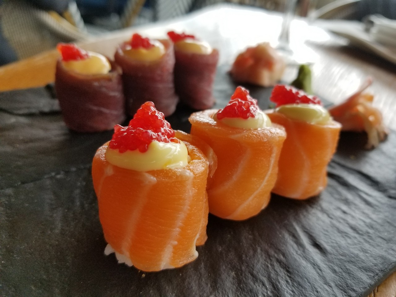 a group of sushi rolls on a black surface