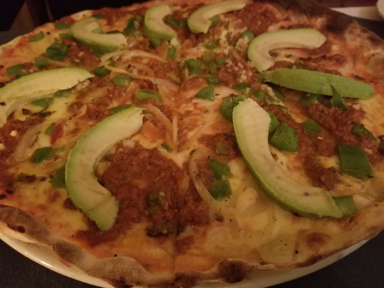 a pizza with avocado slices on top