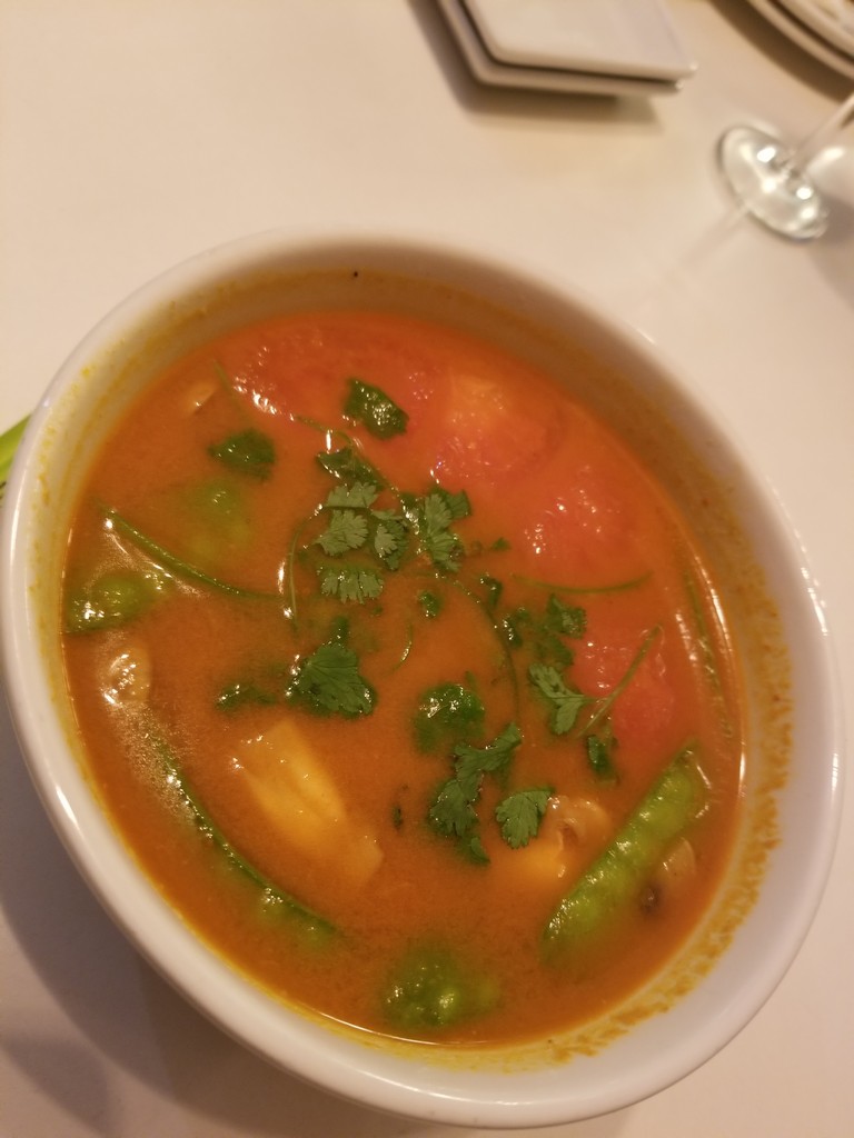 a bowl of soup with vegetables and greens