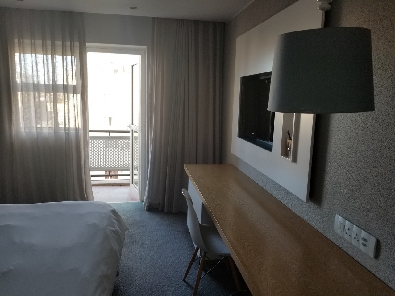 a room with a bed and a desk and a tv