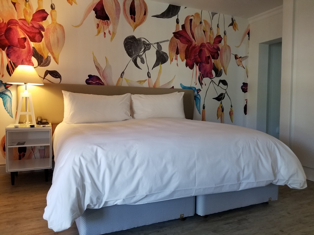 a bed with a floral wallpaper