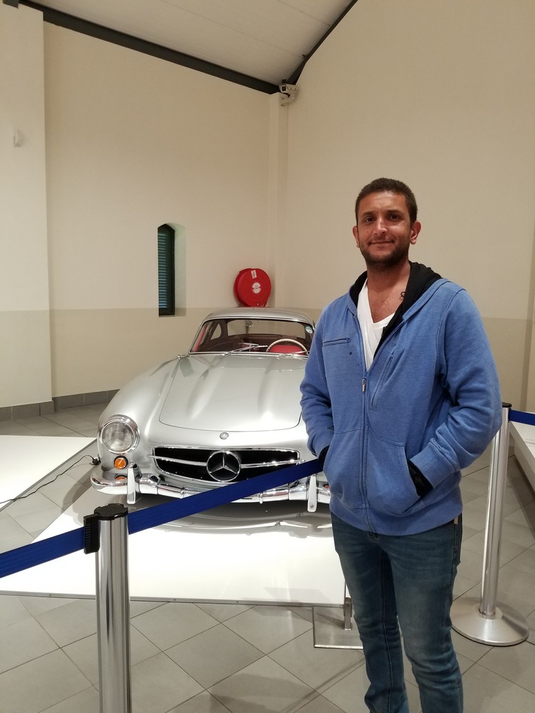 a man standing next to a silver car