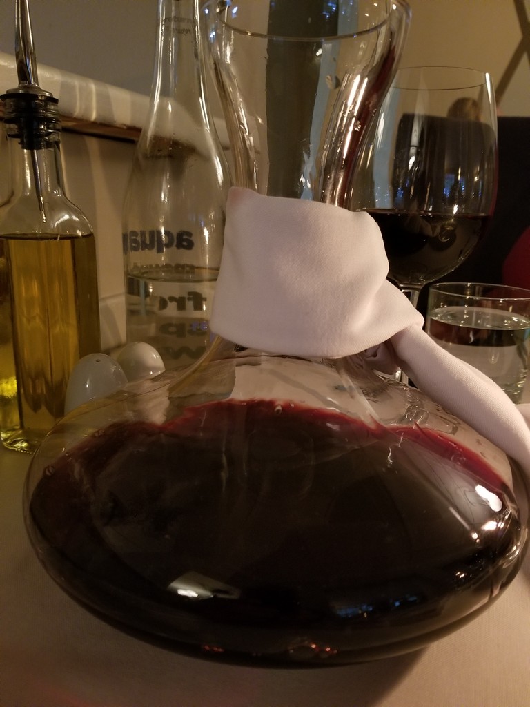 a glass decanter with red liquid