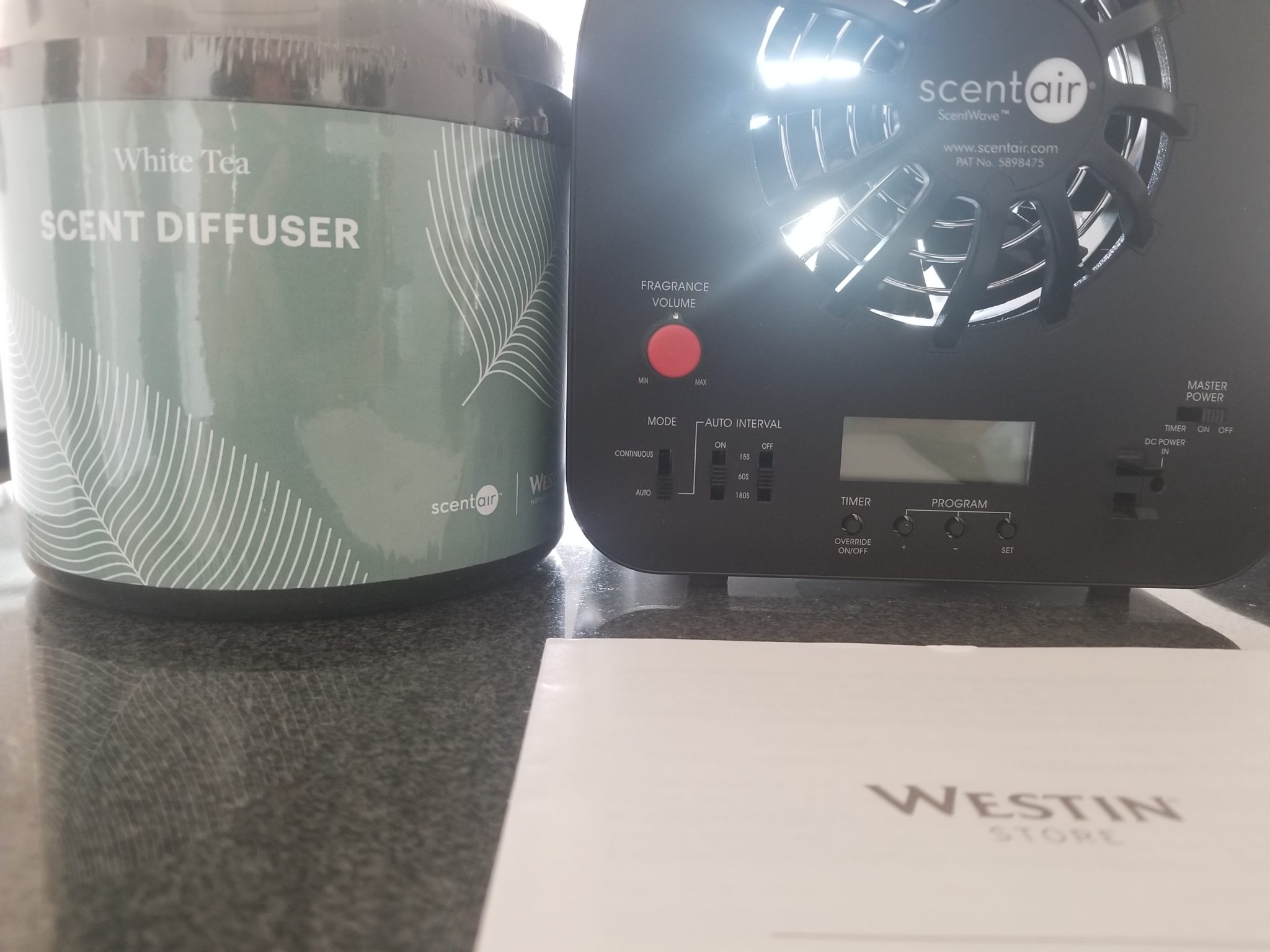 a black box with a fan next to a jar of diffuser