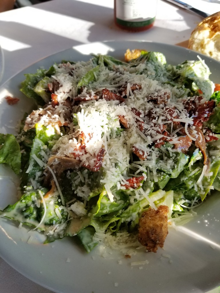 a plate of salad with cheese and bacon