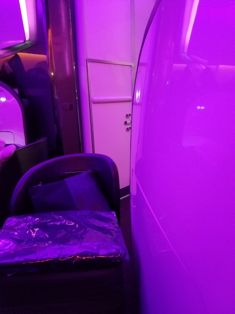 a purple room with a white door and a black bag