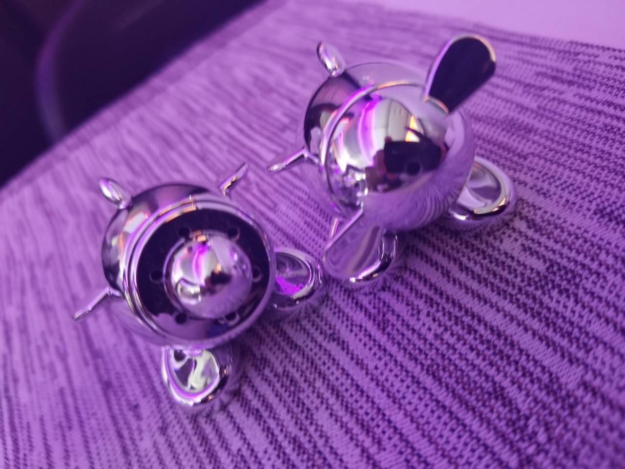 a pair of silver objects on a purple surface