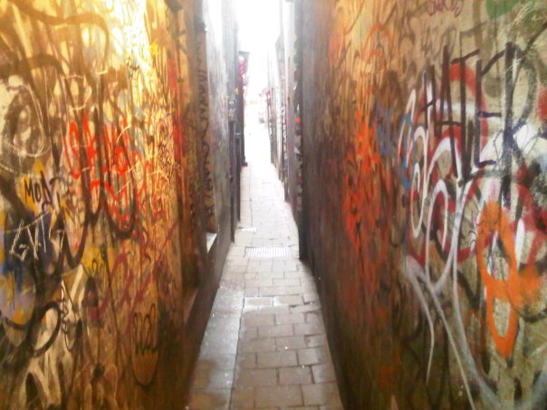 a narrow alley way with graffiti