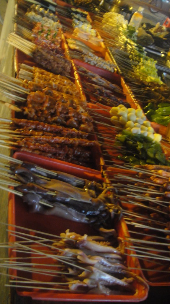 skewers of meat and vegetables on sticks in red containers