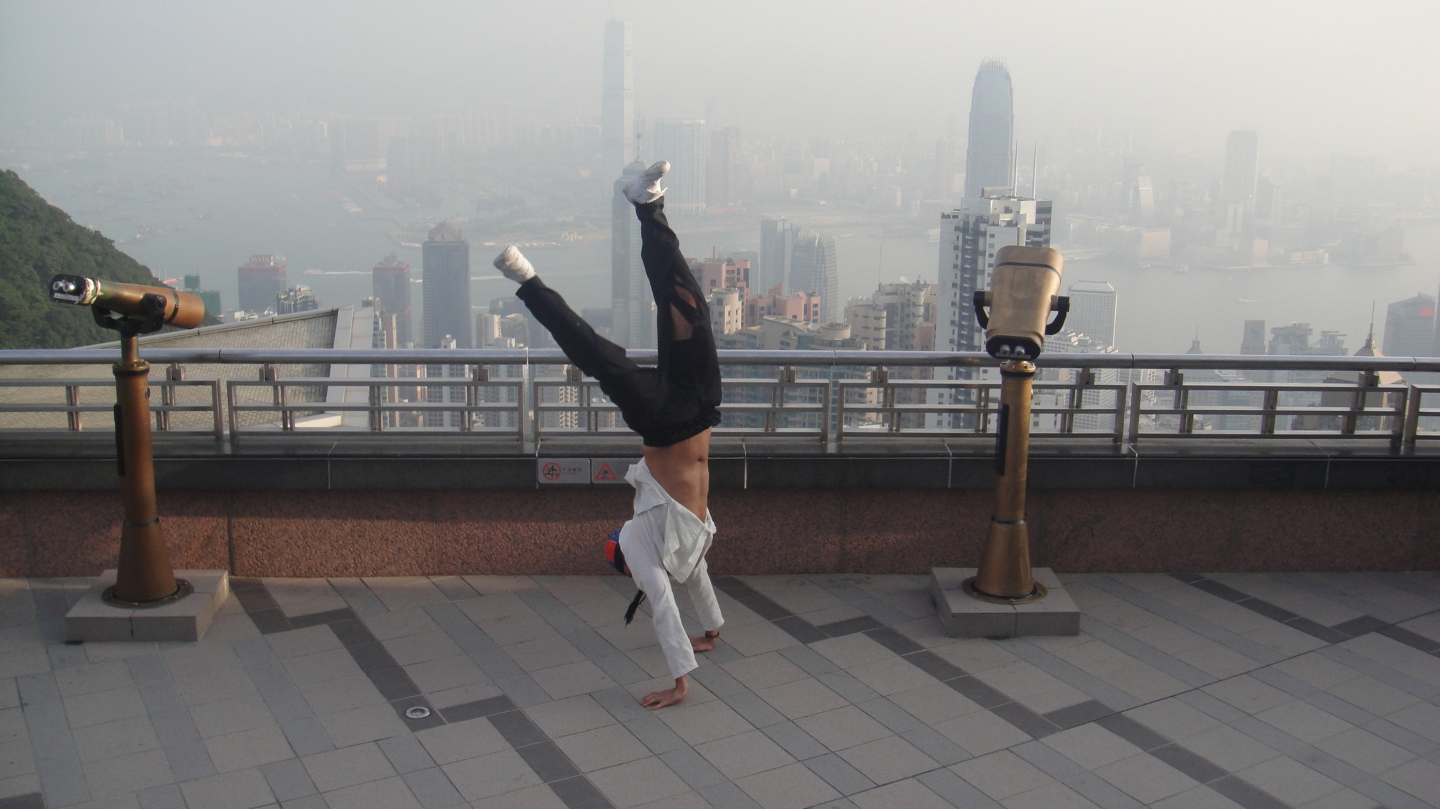 a man doing a handstand on a rooftop