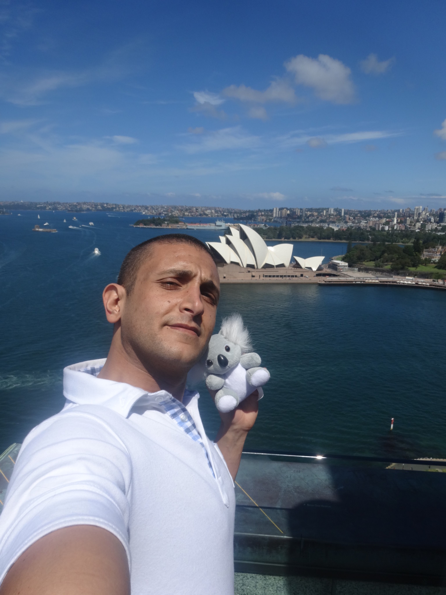 a man taking a selfie with a stuffed animal in front of a body of water