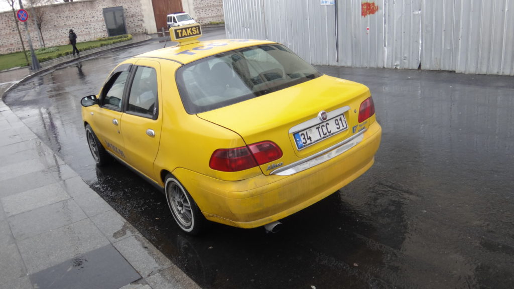 a yellow car parked on a wet street