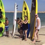 People at beach with surfboards in Kuwait