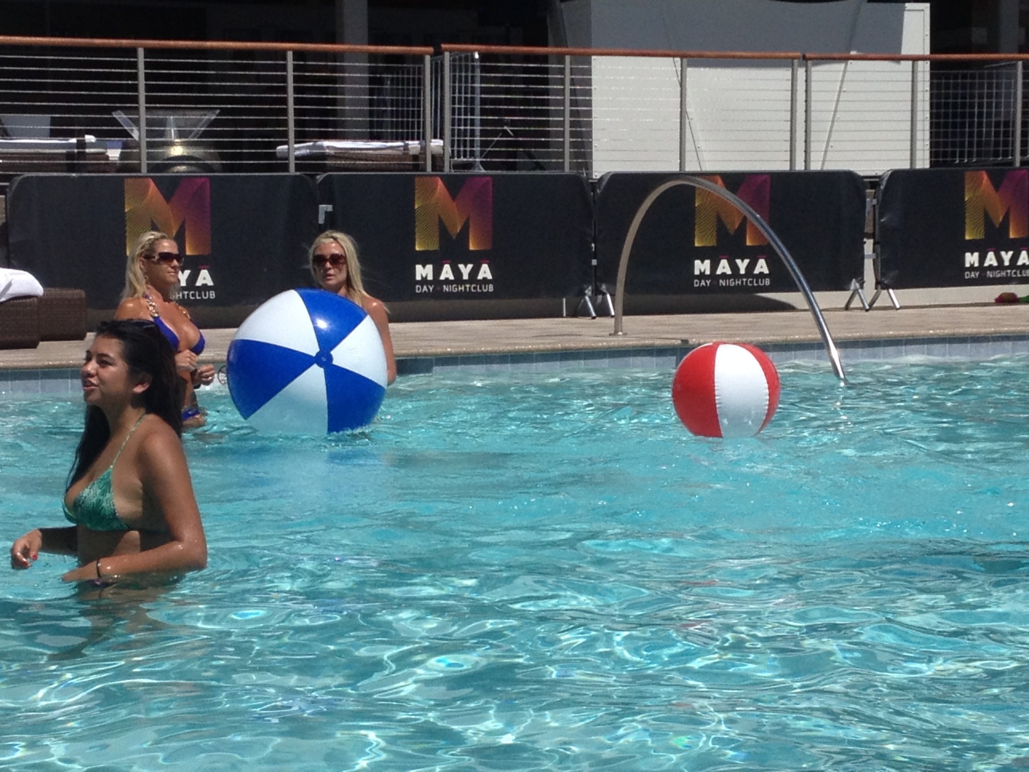 a group of women in a pool with beach balls