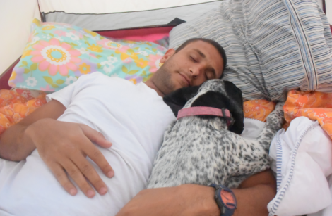 a man sleeping with a dog