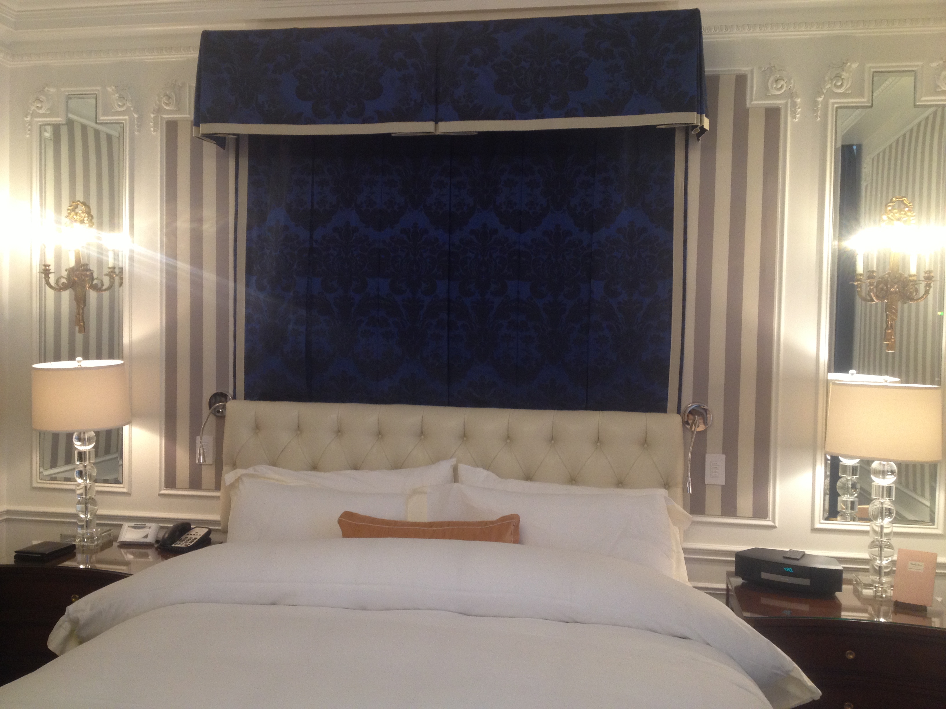 a bed with a blue curtain above it