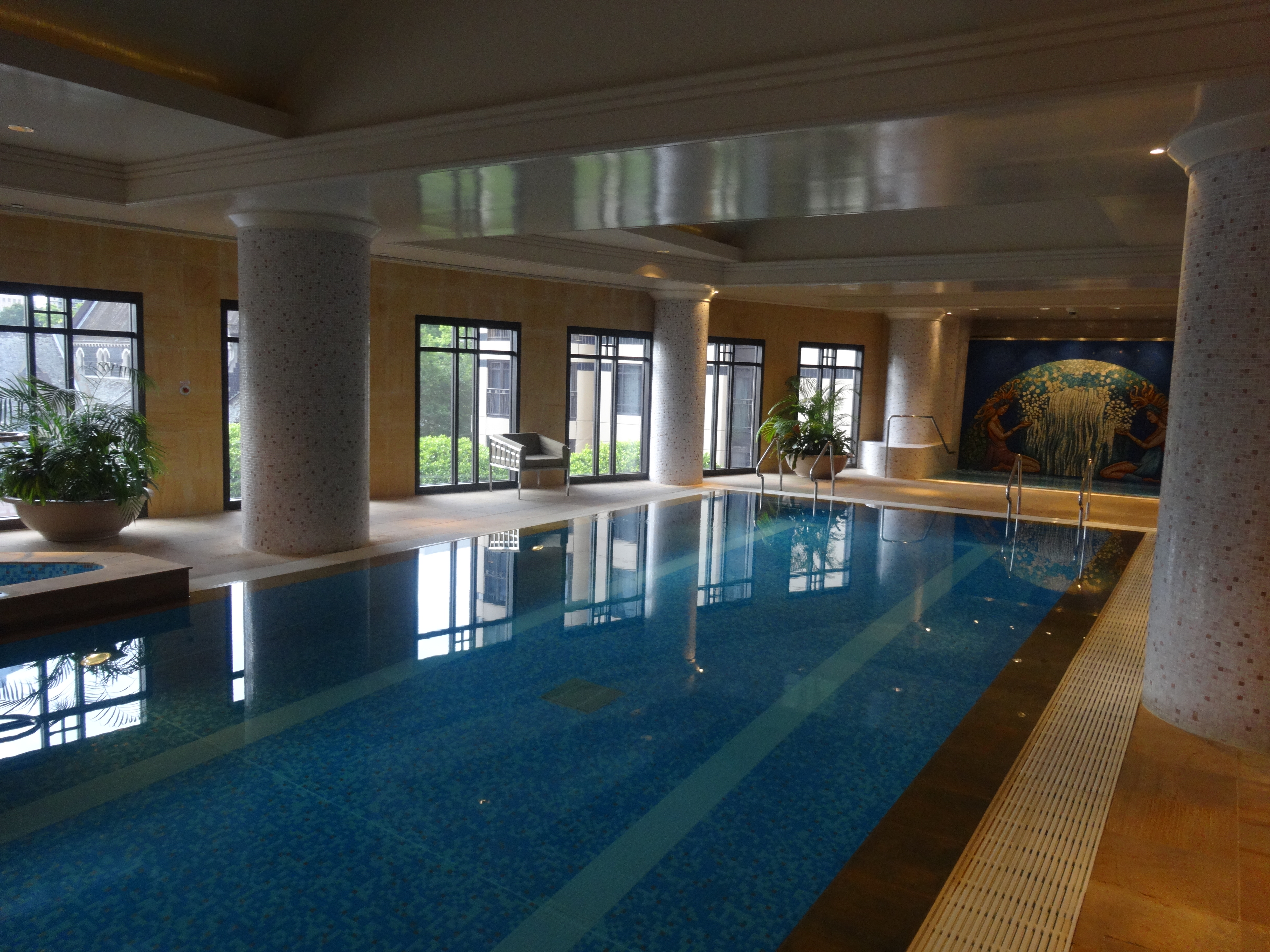 a indoor swimming pool with a large wall and windows