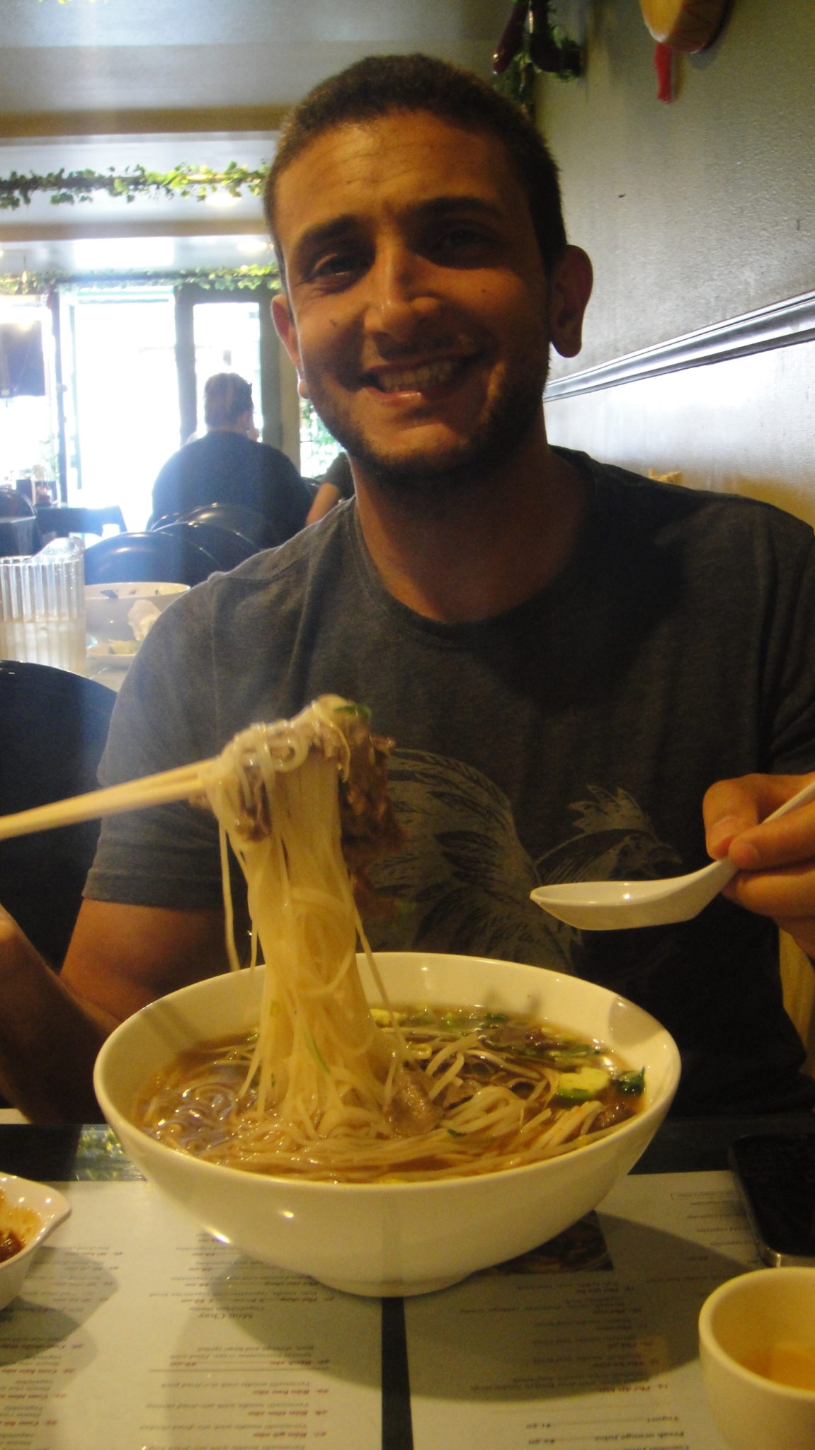 a man eating noodles with chopsticks