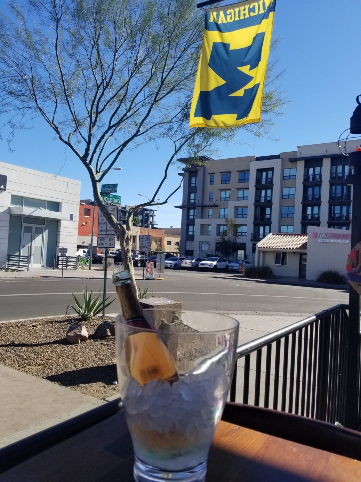 a glass with ice and a bottle in it on a table with a flag
