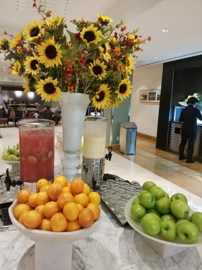 a table with fruit and a vase of flowers