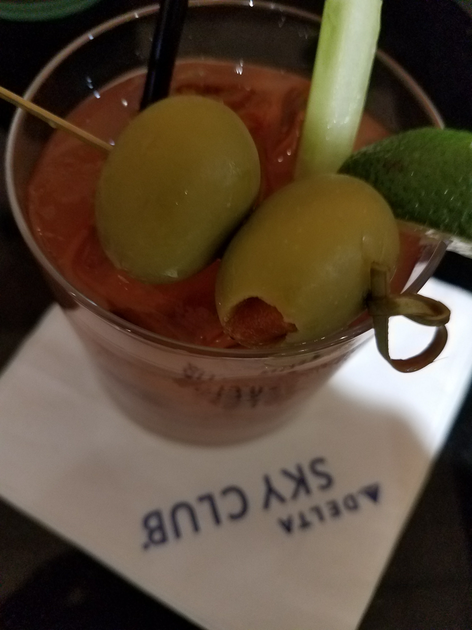 a glass with a drink and olives