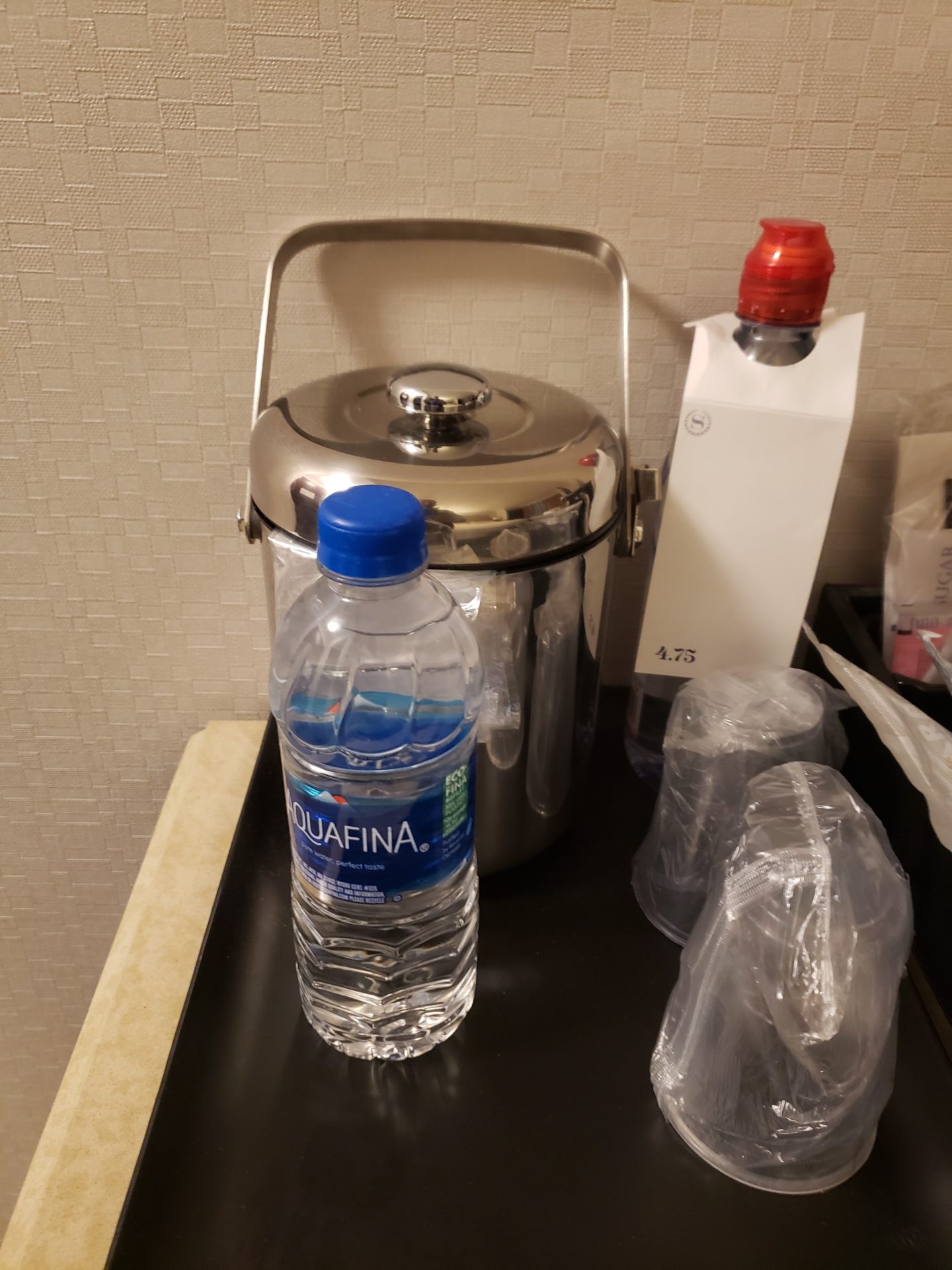 a metal container with a lid and a bottle of water