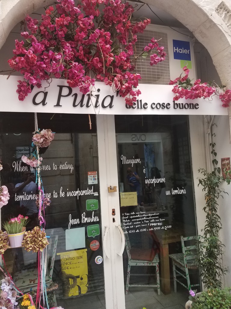 a store front with flowers on the front