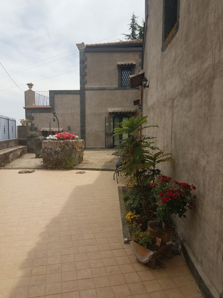 a courtyard with a stone building and flowers