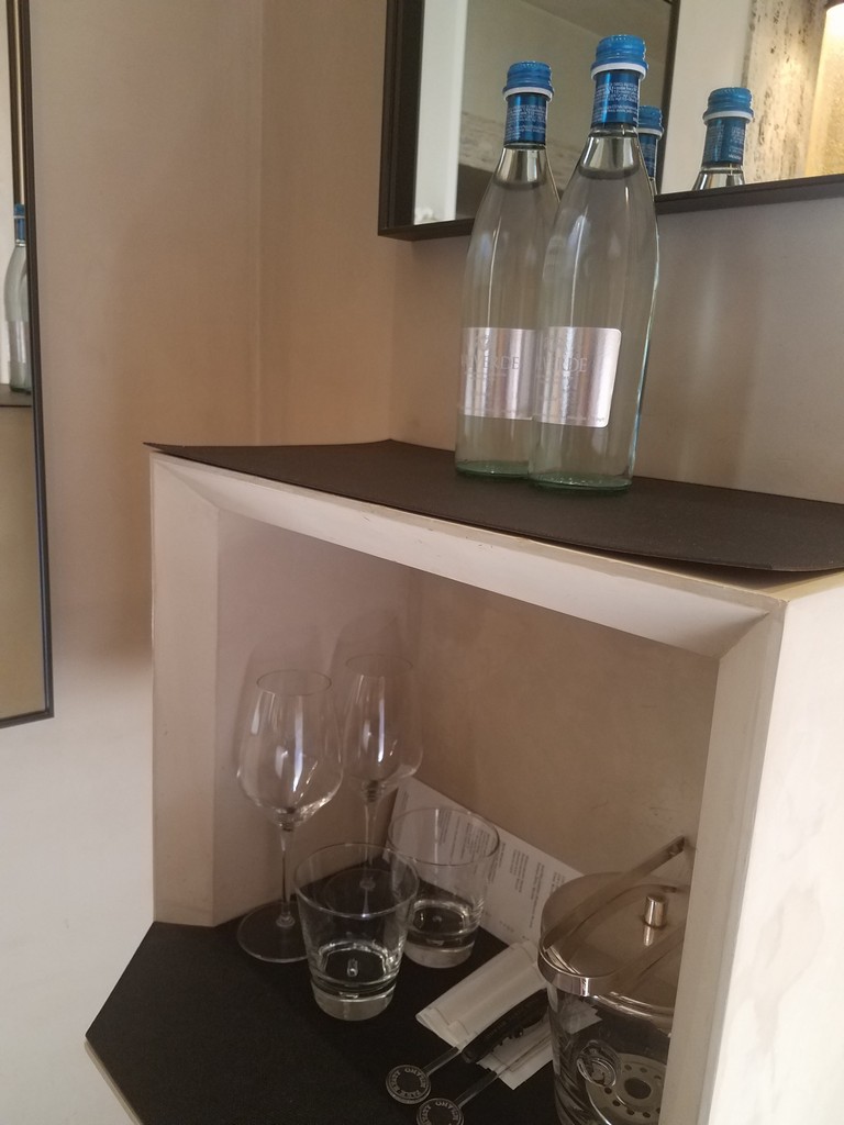 a shelf with wine glasses and bottles