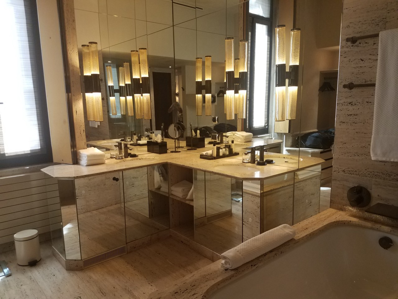a bathroom with a large mirror vanity and a bathtub