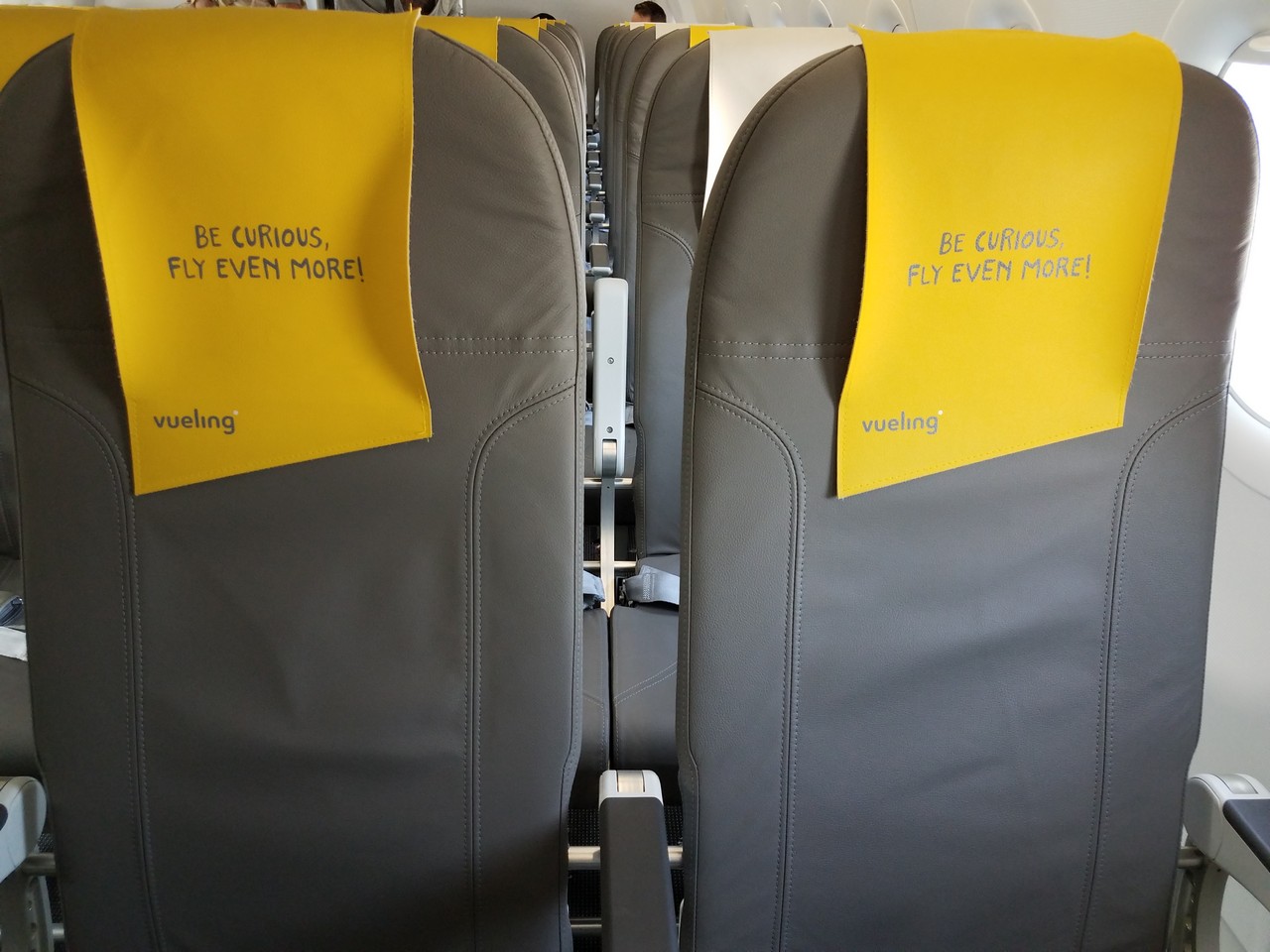a row of seats with yellow and grey signs