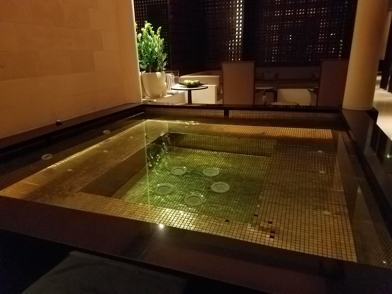 a small square pool with lights on