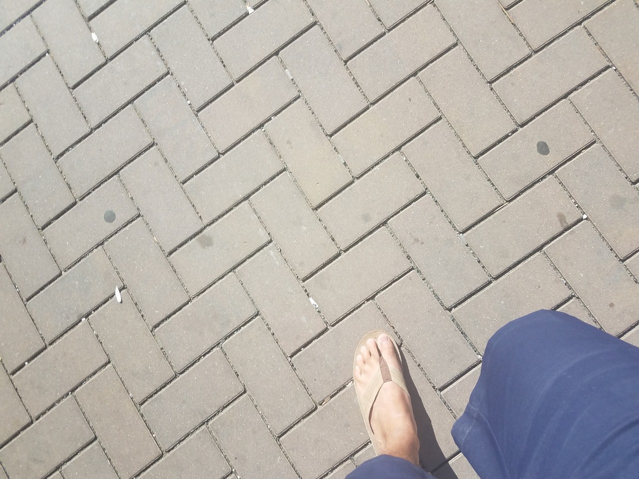 a person's feet on a brick surface
