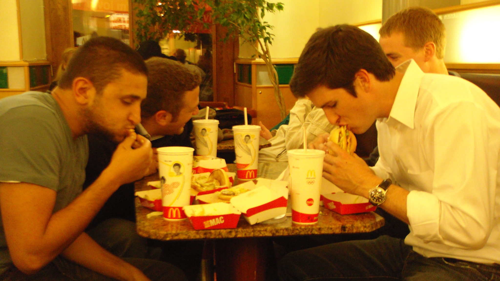 a group of men eating fast food at a table