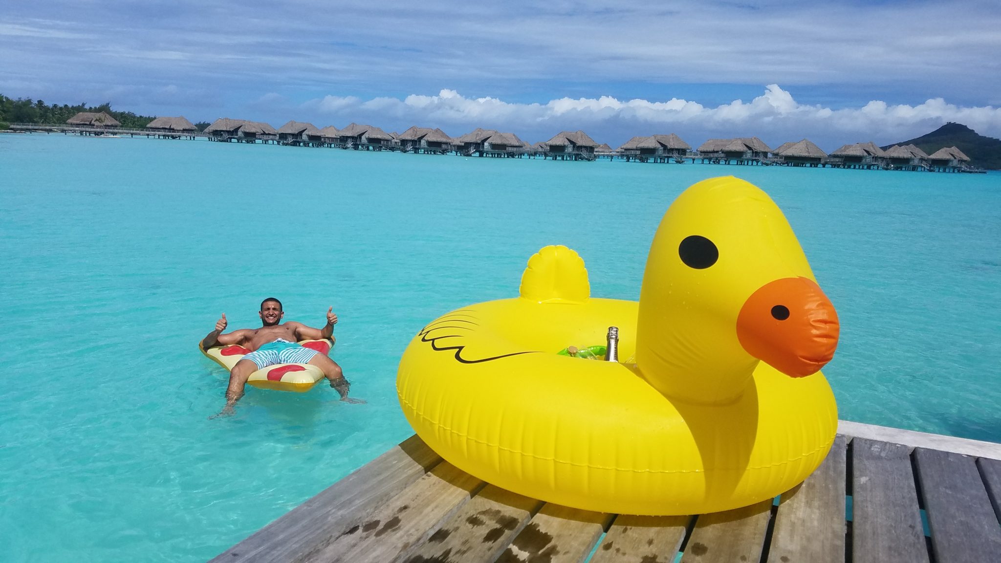 a man floating on a rubber ducky in a pool