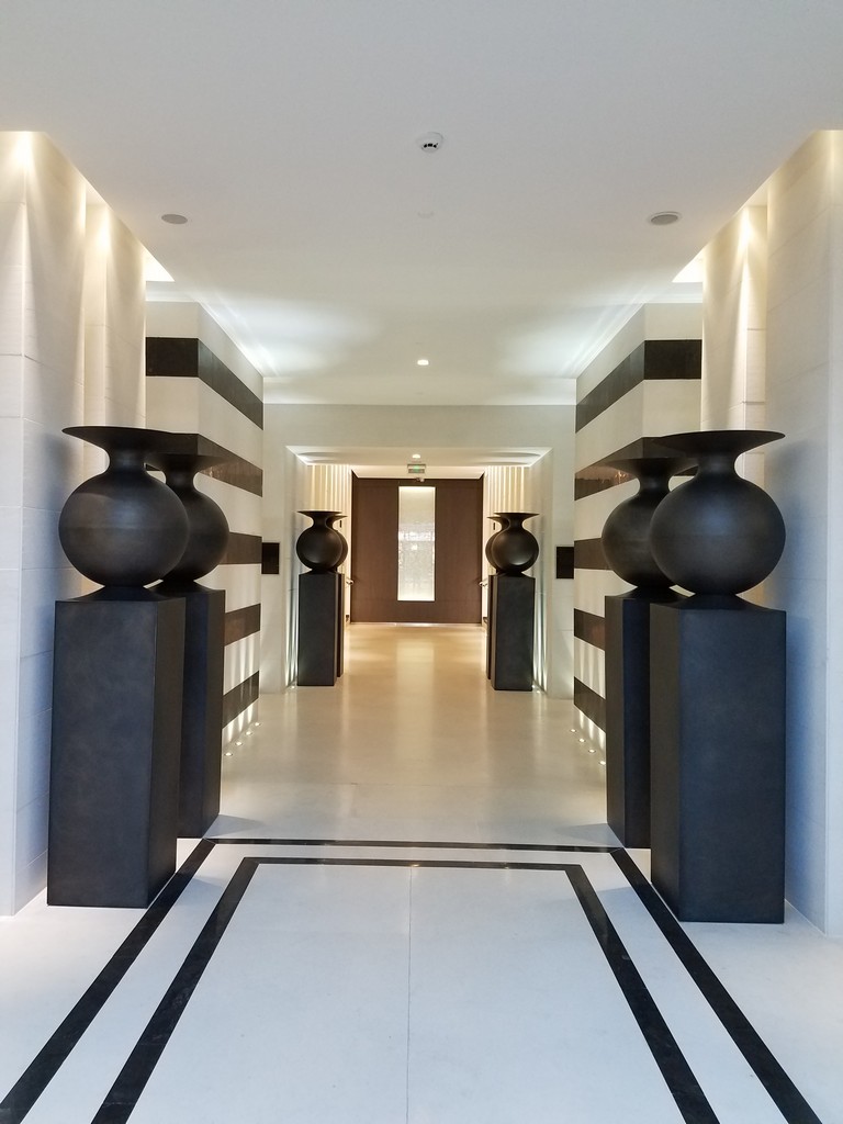 a hallway with black vases