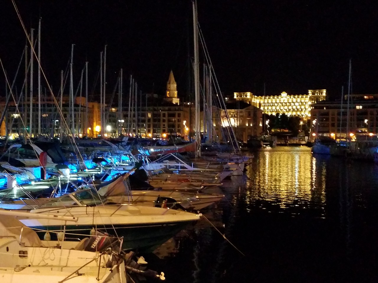 a group of boats in a harbor at night