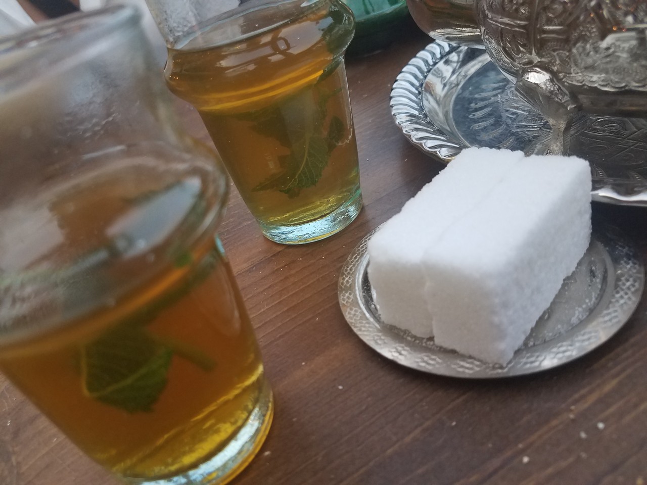 a plate of sugar cubes and a glass of tea