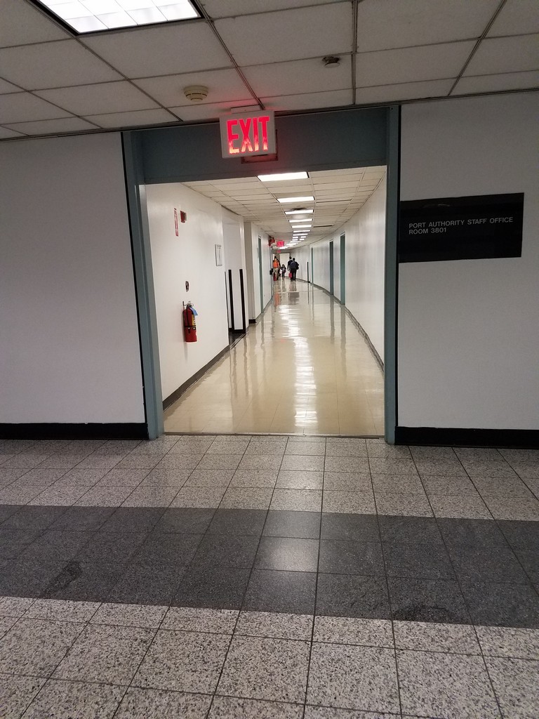 a hallway with a sign and people walking