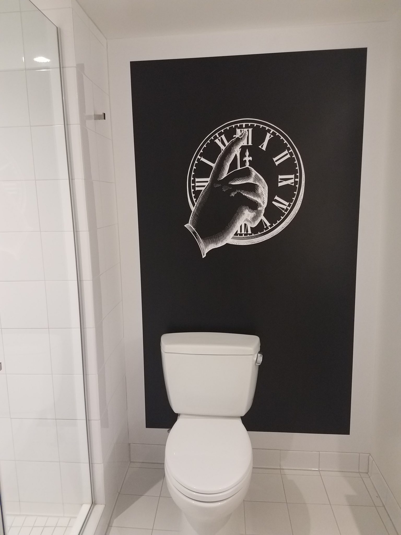 a toilet with a clock on the wall