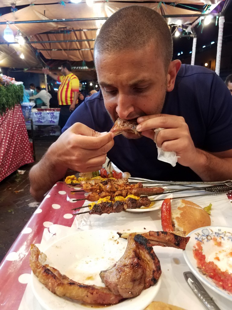 a man eating meat at a table