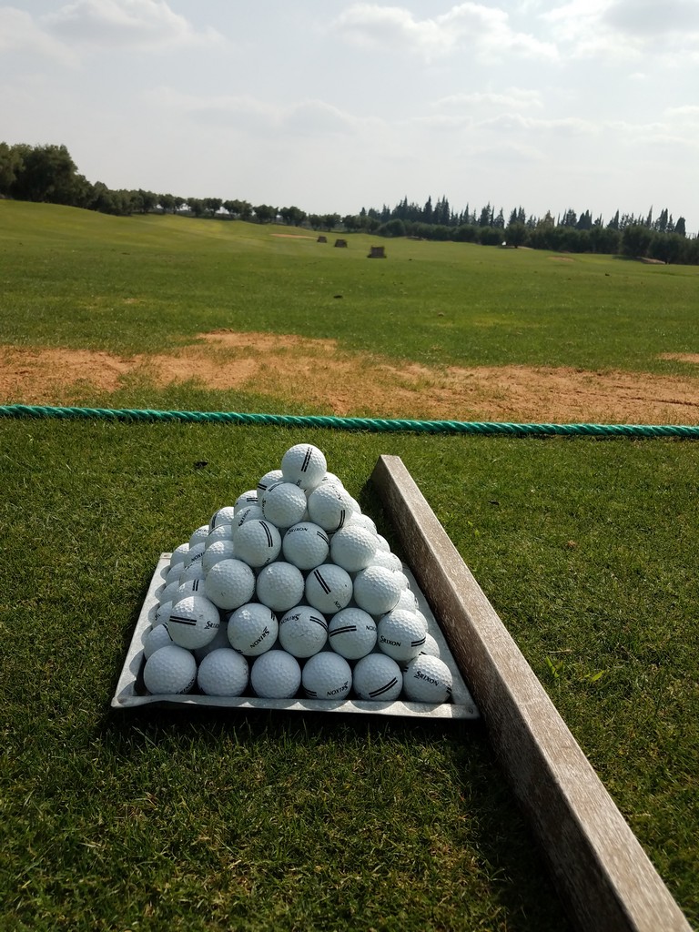 a pyramid of golf balls on a green field