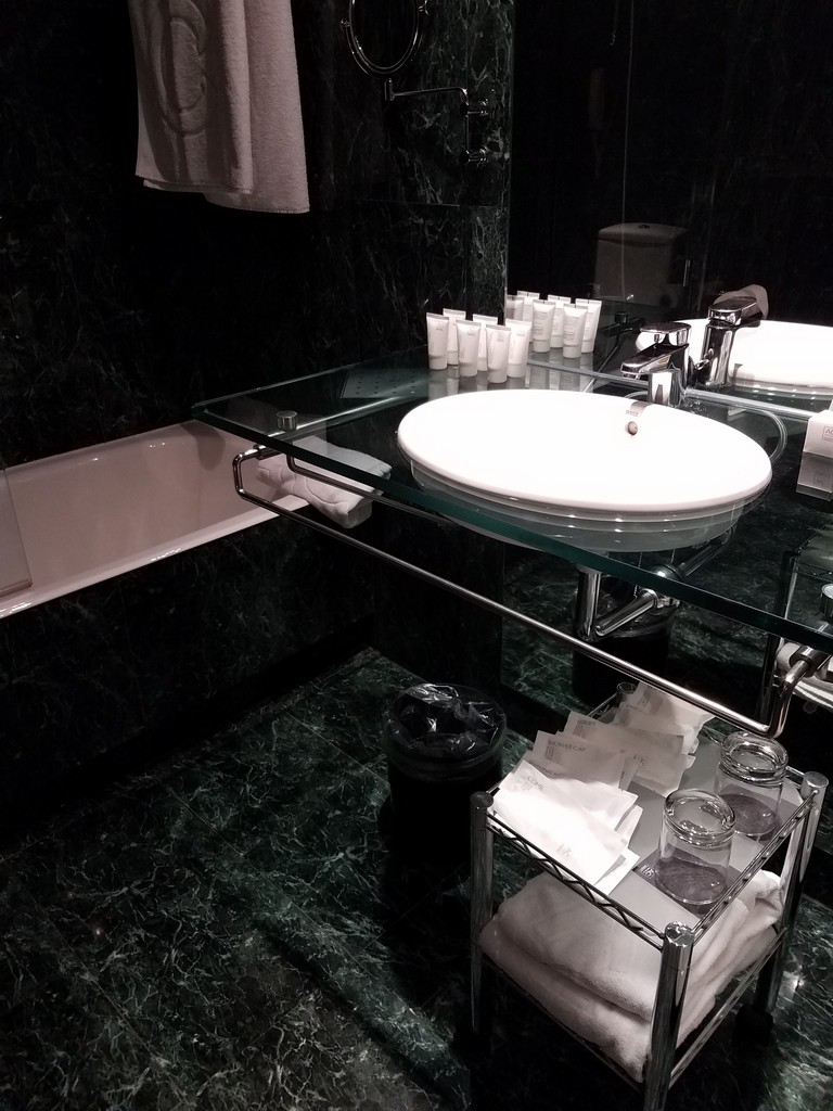 a bathroom with a glass countertop sink and a bathtub