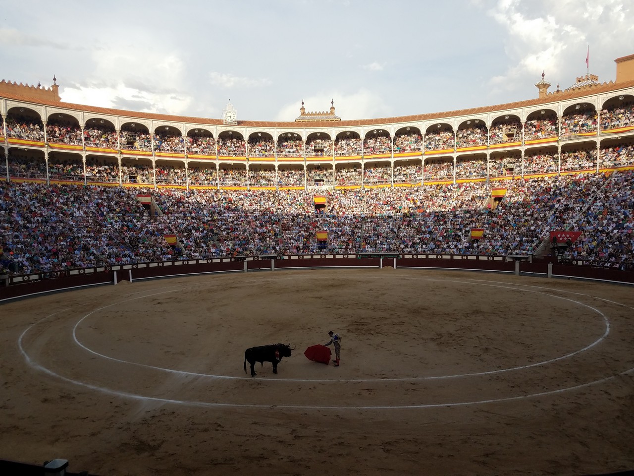 a bull in a arena with a man in a red cape