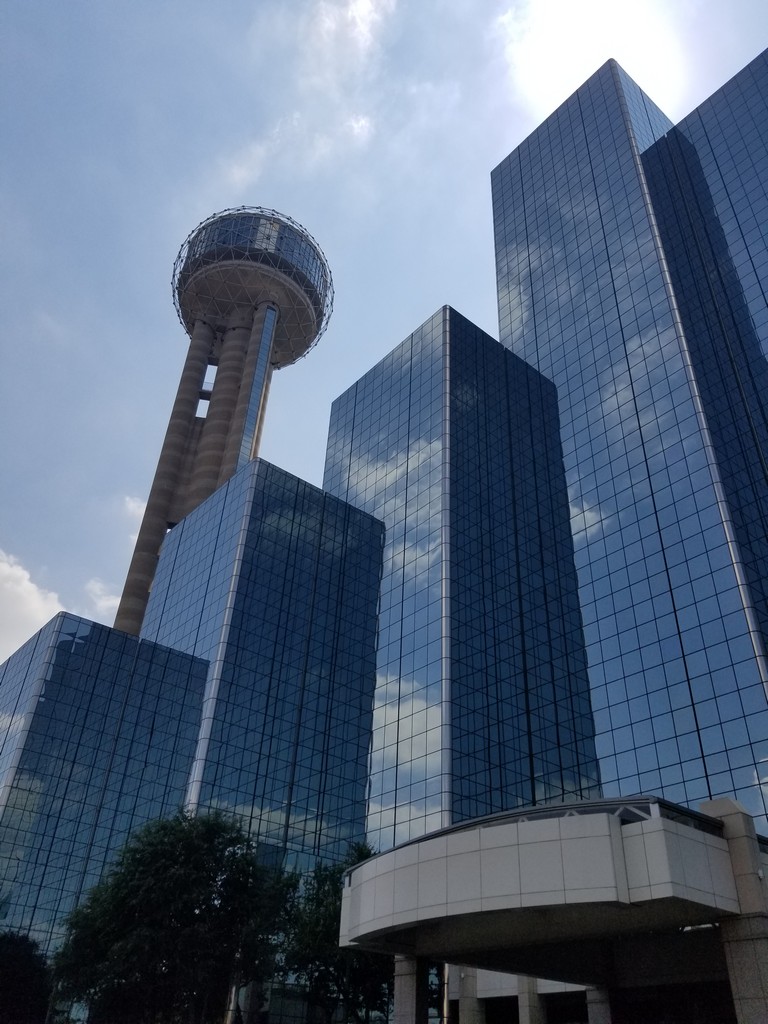 a tall glass buildings with a round tower