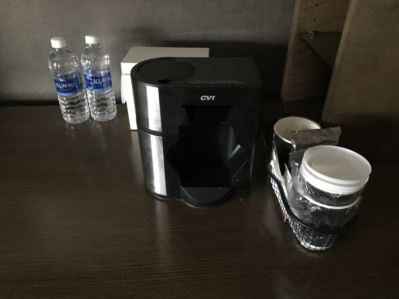 a coffee machine and bottles of water on a table