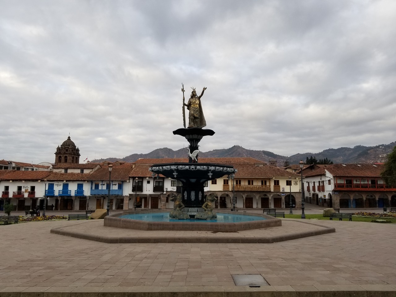 a fountain with a statue in the middle of a town square