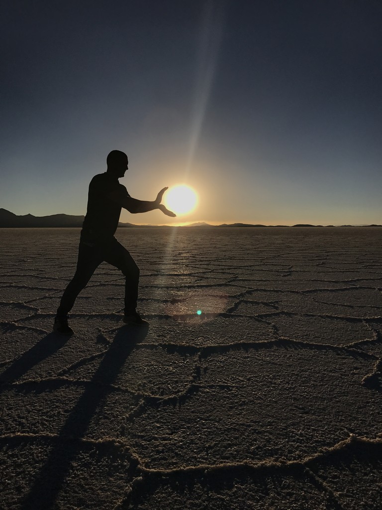 a man holding his hands up in the desert