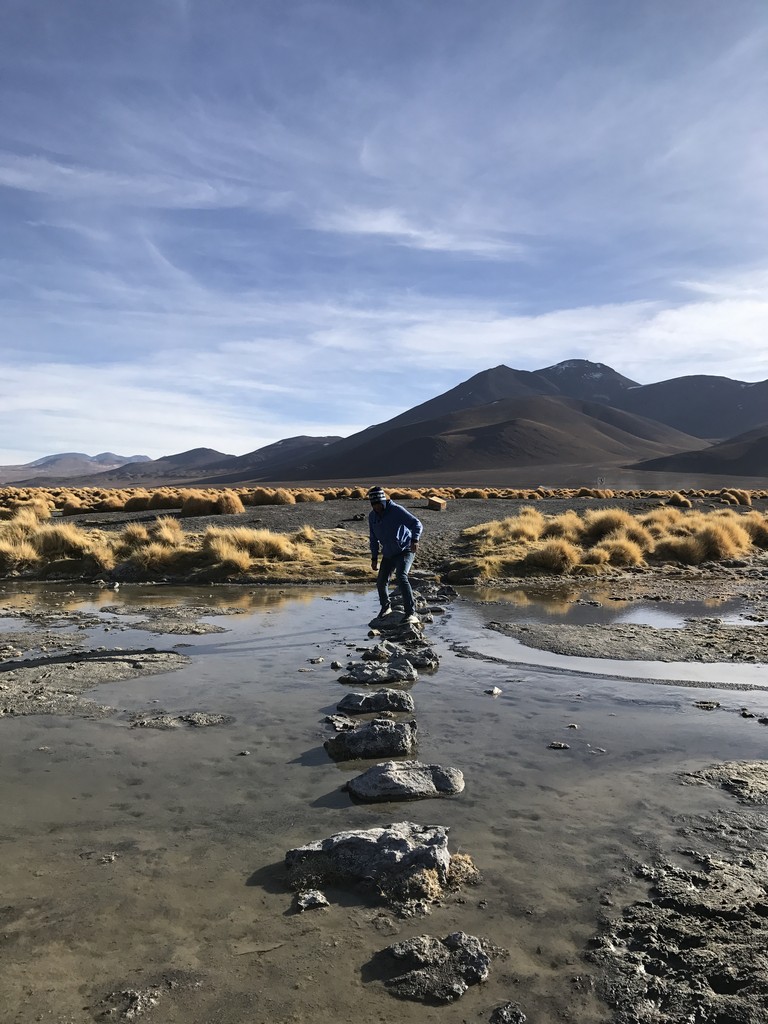 a man walking on rocks in a puddle