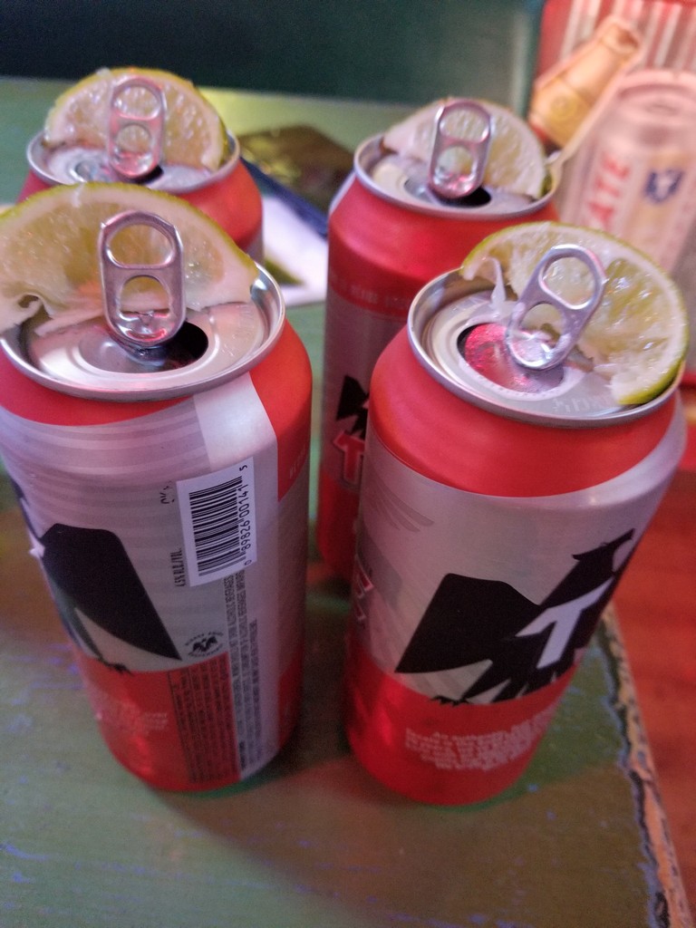 a group of cans with lime slices on top